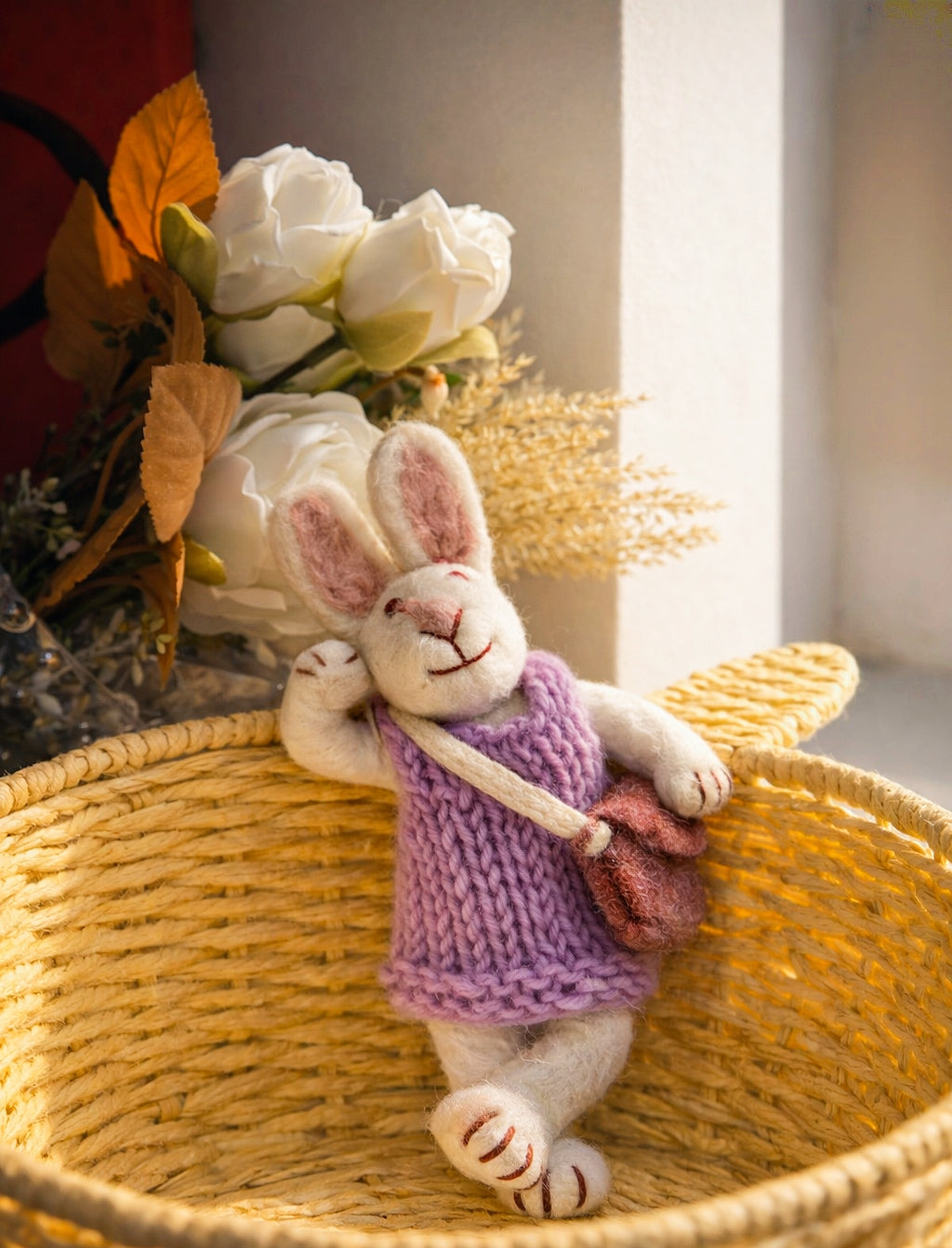 Stuffed rabbit toy in a woven basket with flowers in the background