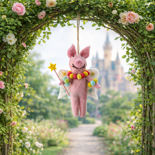 Pink fairy plush toy hanging from a floral arch with a castle in the background